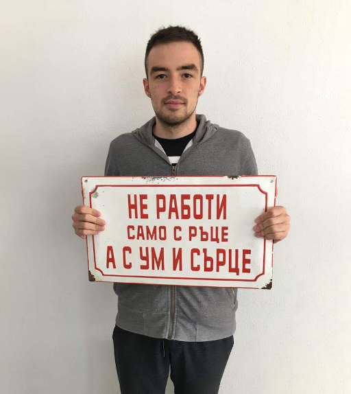 Myself holding a metal Soviet-era sign in Bulgarian.
